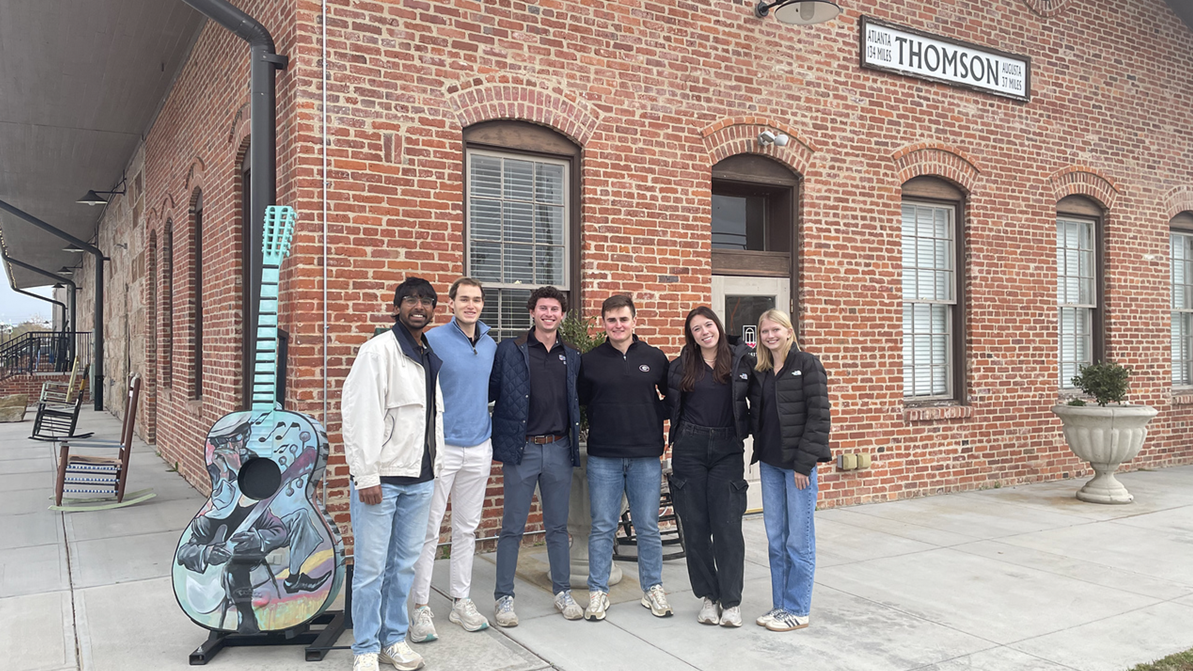 A group of students stand outside of a brick building in Thomson, Georgia